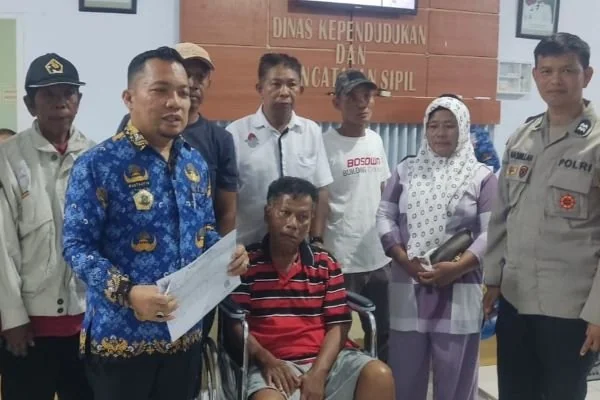 Kepala Disdukcapil Jeneponto, Mustaufiq, bersama Anggota Bhabinkamtibmas, Aiptu Hasbullah saat mendampingi korban kebakaran mengurus dokumen adminduk (Dok : Ist).