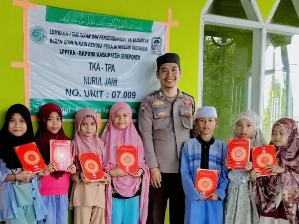 Bripka Siswandi saat membagikan mushaf Al-Qur’an kepada santri Taman Kanak-Kanak Al-Qur’an (TKA) Masjid Nurul Jami Bontomanai (Dok : Ist).