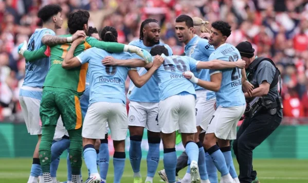 Pemain Manchester City berkumpul dalam huddle jelang final Carabao Cup melawan Arsenal di Wembley Stadium (22/3). Foto: David Klein/REUTERS