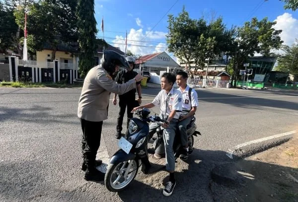 Polres sinjai saat mengedukasi pelajar yang tidak menggunakan helm (Dok : Ist).