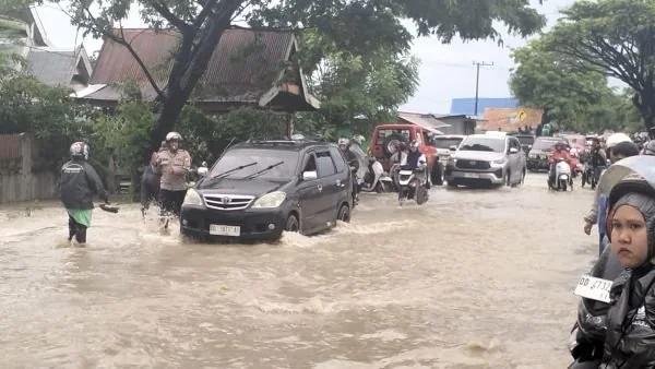 Anggota Polsek Bangkala saat mengatur arus lalulintas ditengah situasi banjir (Dok : Ist).