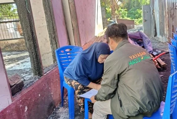 Tim Program Humanity and Environment Lembaga Amil Zakat (LAZ) Hadji Kalla menyerahkan bantuan berupa voucher belanja kepada warga pasca kebakaran (Dok: Ist)