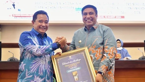 Pj Gubernur Sulsel, Bahtiar Baharuddin, menyerahkan perhargaan kepada Bupati Maros, Chaidir Syam, Jumat, (15/3).