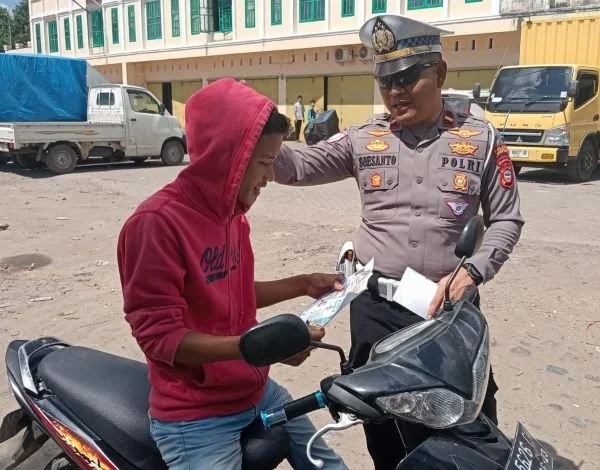 Anggota Polres Takalar saat menilang pengendara yang tidak menggunakan helm (Dok : Saleh KabarMakassar).