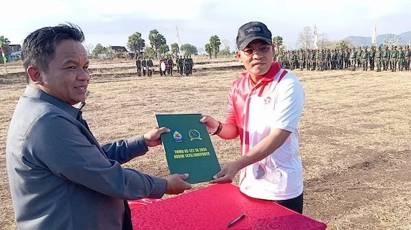 Dandim 1425 Jeneponto, Letkol Inf. Muhammad Amin saat memberikan dokumen TMMD ke Pj. Bupati Junaedi Bakri di Desa Tuju Kecamatan Bangkala Barat. (Foto/ist).