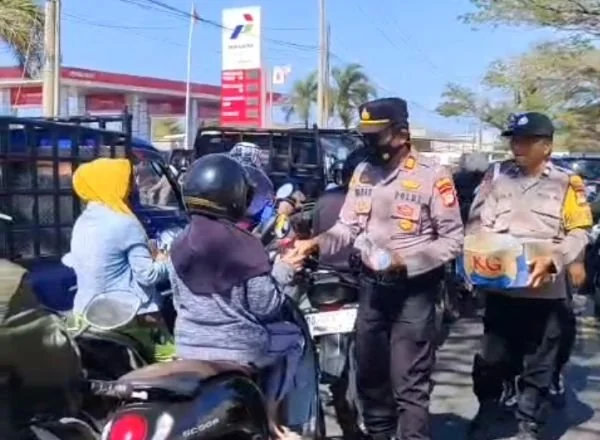 Kapolsek Arungkeke, AKP Baharuddin saat membagikan air mineral kepada pengendara yang antri BBM di SPBU Bulo-bulo (Dok: Ist)