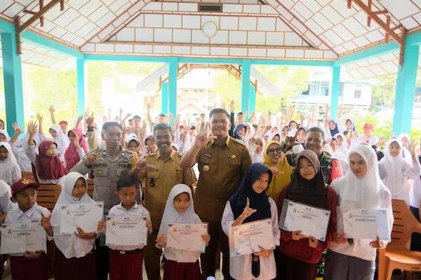 Bupati Bantaeng M Fathul Fauzy Nurdin saat menyerahkan beasiswa secara simbolis kepada salah seorang pelajar berprestasi di Desa Labbo. (Ist).