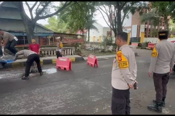 Kapolres Jeneponto bersama jajarannya saat menambal jalan berlubang di seputaran Jl Pelita (Dok : Ist).