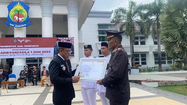 Bupati Jeneponto Paris Yasir saat memberikan penghargaan kepada Kasat Binmas Polres Jeneponto, AKP Muh. Natsir. (Ist).