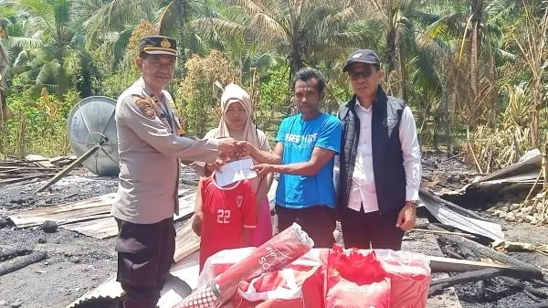 Kapolsek saat menyerahkan bantuan dan membangunkan tenda hunian sementara (Dok : Ist).