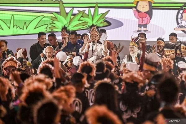 Presiden Joko Widodo (tengah) bersama Ibu Negara Iriana Joko Widodo (kanan) menyapa anaka-anak saat menghadiri peringatan Hari Anak Nasional Ke-40 di Istora Papua Bangkit, Jayapura, Papua, Selasa (23/7/2024). Hari Anak Nasional bertema "Anak Terlindungi,
