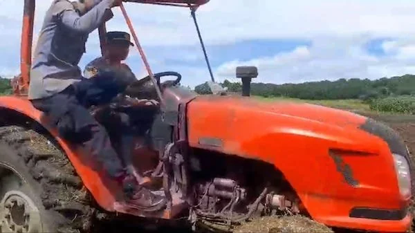 Kapolsek Bangkala, AKP Saifullah Syan saat berjibaku mengoperasikan satu unit traktor PTPN Takalar dalam membantu mengolah lahan di Kelurahan Bulujaya, Kecamatan Bangkala Barat, Kabupaten Jeneponto. (Foto/ist).