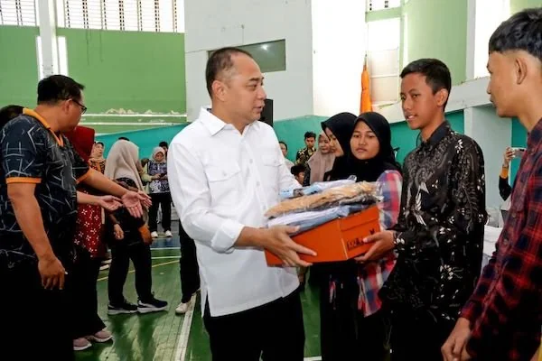 Wali Kota Surabaya Eri Cahyadi (tengah) menyerahkan paket bantuan pendidikan kepada pelajar SMA/SMK/MA sederajat di Gelanggang Remaja Surabaya, Jumat (10/7/2026). Bantuan pendidikan Pemerintah Kota Surabaya tersebut menjangkau 7.380 siswa dari keluarga mi