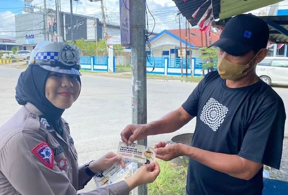 Polwan saat membagikan stiker kepada para tukang ojek