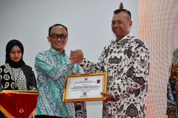 PJ gubernur Sulbar saat menyerahkan sejumlah penghargaan kepada instansi.