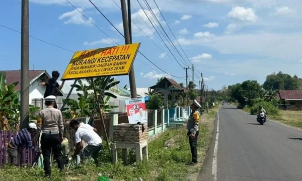 Anggota Sat Lantas Polres Sinjai dibantu warga sekitar memasang papan himbauan (Dok : Ist).