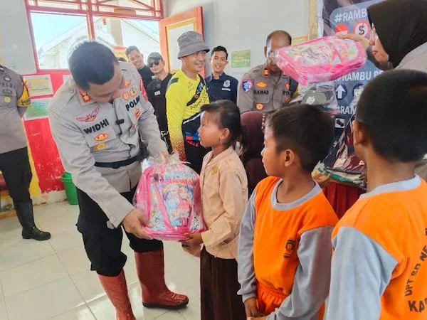 Kapolres Jeneponto, AKBP Widi Setiawan saat menyerahkan perlengkapan sekolah kepada siswa-siswi SD Negeri 234 Pulau Harapan Kabupaten Jeneponto. (Ist).