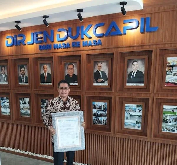 Kadisdukcapil Gowa saat Menerima Sertifikat ISO Keamanan Data (Dok: Ist).