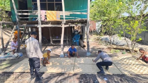 Personel kepolisian bahu-membahu dengan warga sekitar, saat bekerja sama memperbaiki rumah Nenek Saniba (Dok : Ist).