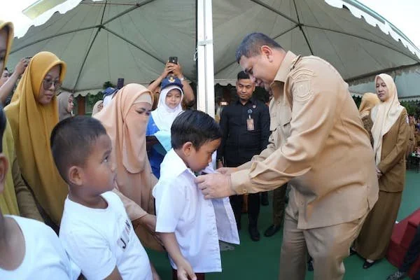 Wali Kota Makassar Munafri Arifuddin saat Memasangkan Seragam ke Siswa, (Dok: Kabar Makassar).