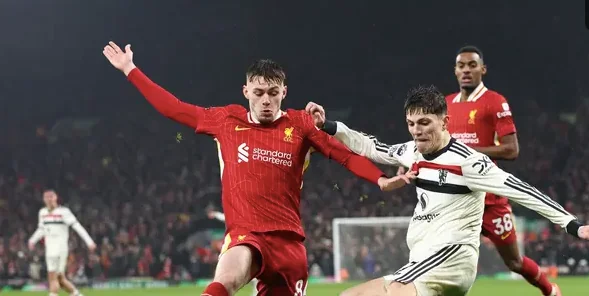 Bek Liverpool asal Irlandia Utara Conor Bradley (tengah) beradu dengan gelandang Manchester United asal Argentina Alejandro Garnacho (kanan) selama pertandingan sepak bola Liga Primer Inggris antara Liverpool dan Manchester United di Anfield di Liverpool,