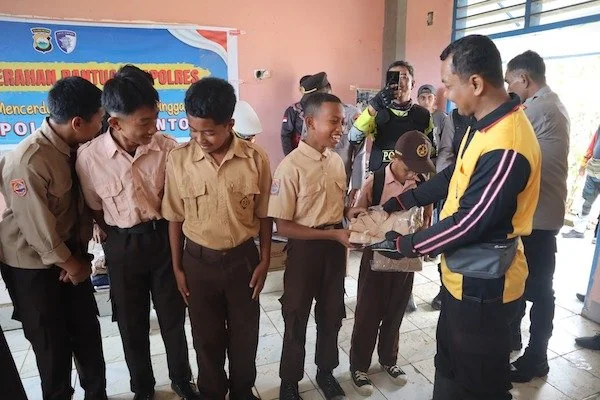 Kapolres Jeneponto, AKBP Widi Setiawan saat menyerahkan seragam gratis ke sejumlah pelajar di Rumbia.