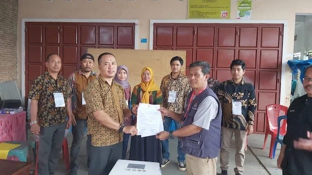 Anggota KPU Makassar, Muh Abdi Goncing saat proses serah terima surat suara yang sudah dipakai dari KPPS 021 Katimbang ke PPS pada pelaksanaan PSU, Sabtu (24/2).