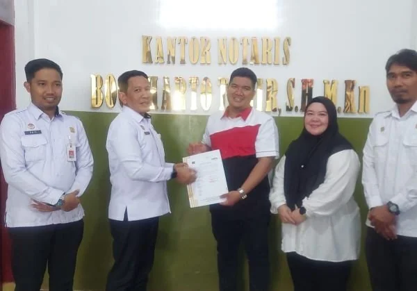 Kepala Kantor Wilayah Kemenkum Sulsel, Andi Basmal saat menyerahkan berkas exit meeting pelaksanaan audit PMPJ pada Notaris Bogi Harto. Dok. Ist