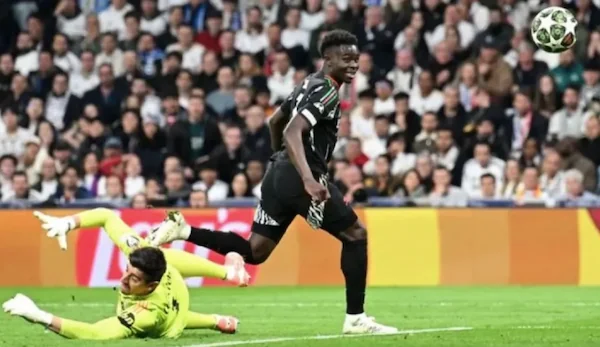 Pemain Arsenal,Bokayo Saka (kanan), melawati penjaga gawang Real Madrid,pada leg kedua perempat final Liga Champions di Stadion Santiago Bernabeu, Madrid, Kamis dini hari WIB (17/4/2025). https://www.arsenal.com/pri.