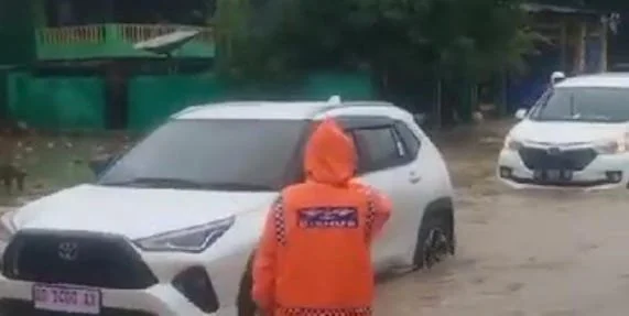 Banjir setinggi 20-30 saat menggenangi  dJalan Poros Jeneponto-Makassar, tepatnya Sarroanging, Kelurahan Bontotangnga, Kecamatan Tamalatea. (Ist).