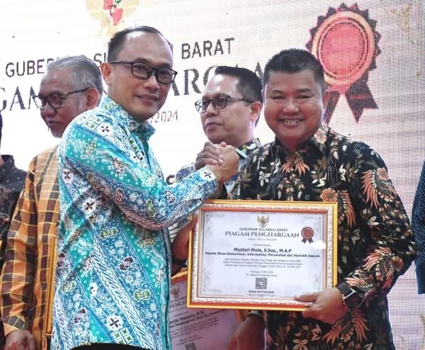 PJ Gubernur Sulbar saat menyerahkan penghargaan kepada Kadis Kominfo Sulbar.
