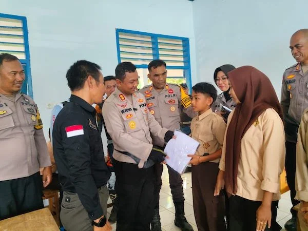 Kapolres Jeneponto, AKBP Widi Setiawan saat memberikan Perlengkapan Sekolah Gratis ke Pelajar. (Ist).