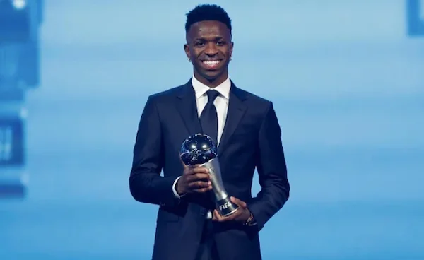 Penyerang Real Madrid Vinicius Junior menerima trofi Pemain Terbaik Pria FIFA 2024 di Doha, Qatar, Selasa (17/12/2024) malam waktu setempat. (Foto: X/@vinijr)