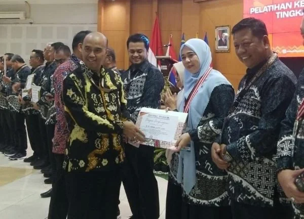 Kepala Dinas Pengendalian Penduduk dan Keluarga Berencana (DP2KB) Kabupaten Jeneponto, Dr. St. Meriam, S.STP., M.Si saat menerima penghargaan pada ajang Pendidikan Kepemimpinan Nasional (PKN) Tingkat II Angkatan IV Tahun 2026 yang diselenggarakan BPSDM Pr