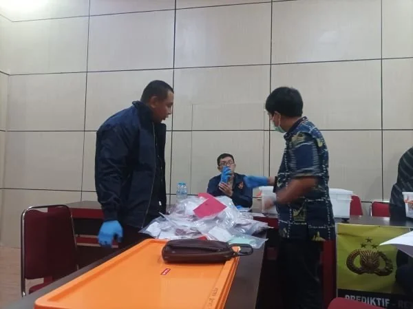 Perhitungan dan pengecekan uang palsu oleh polisi (Dok: Ist)