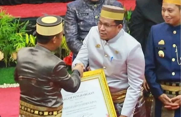 Sekda Sidrap saat menerima penghargaan dari Gubernur Sulsel (dok. Ist)