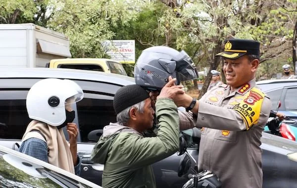 Kapolrestabes Makassar, Kombes Pol Mokhamad Ngajib saat memberikan helm pada pengendara (Dok:Ist)