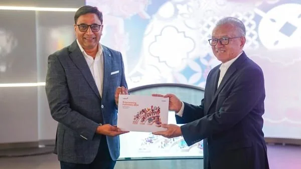President Director & CEO IOH Vikram Sinha saat memberikan Buku Empowering Indonesia Report 2024 kepada Komisaris Utama IOH Halim Alamsyah yang diadakan di Jakarta,