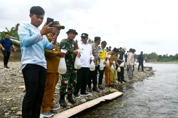 Pj Gubernur Sulbar bersama rombongan saat menebar benih ikan nila di Malunda (Dok : Ist).