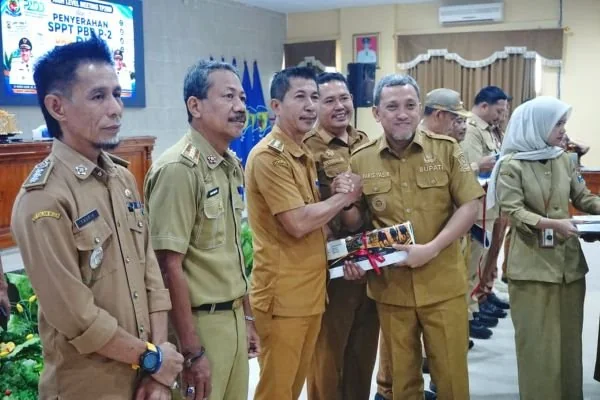 Bupati Jeneponto, Paris Yasir saat mendistribusikan Surat Pemberitahuan Pajak Terutang (SPPT) Pajak Bumi dan Bangunan Perdesaan dan Perkotaan (PBB-P2) serta Daftar Himpunan Ketetapan Pajak (DHKP) Tahun 2026 kepada salah satu camat. (Dok: Ist)