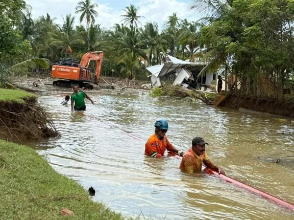 Tim khusus PLN UID Sulselrabar dibantu masyarakat tengah memobilisasi tiang melewati akses yang masih terendam banjir di Desa Kuala Kereutou, Kecamatan Lapang, Kabupaten Aceh Utara. (Dok: Ist)