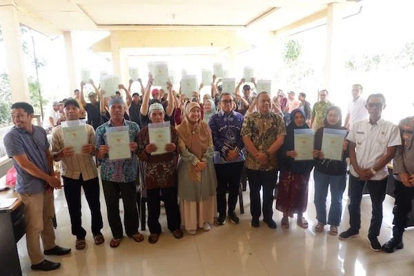 Bupati Jeneponto, Paris Yasir bersama Kepala Kantor Pertanahan Jeneponto, Dadang, Kepala Dinas Koperasi, Camat Rumbia, serta perwakilan Babinsa dan Bhabinkamtibmas, serta masyarakat berswafoto usai penyerahan sertifikat. (Ist).