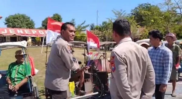 Kapolres Jeneponto, AKBP Widi Setiawan  bersama Kasat Binmas, AKP M. Natsir, saat bagikan bendera ke tukang becak. (Foto/ullah).