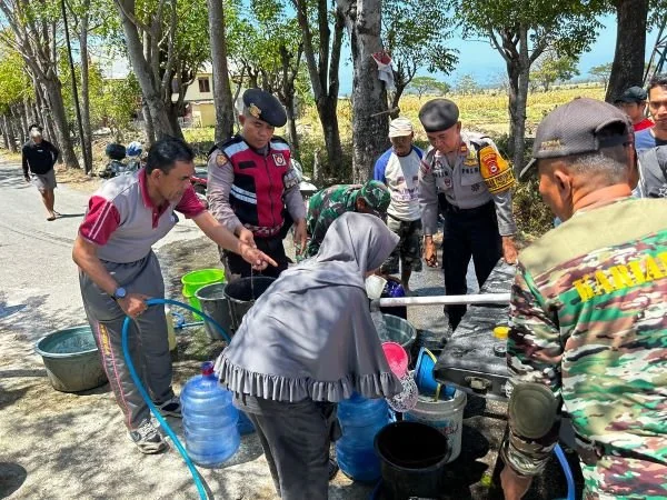 Kasat Binmas Jeneponto, AKP Muh. Nasir bersama Kasat Sabhara, Iptu Yasiruddin saat mendistribusikan air bersih kepada warga di Desa Camba-camba (Dok : Ist).