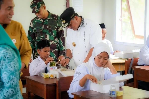 Pj Gubernur Sulbar saat melakukan uji coba makan gratis di Pasangkayu (Dok : Ist).