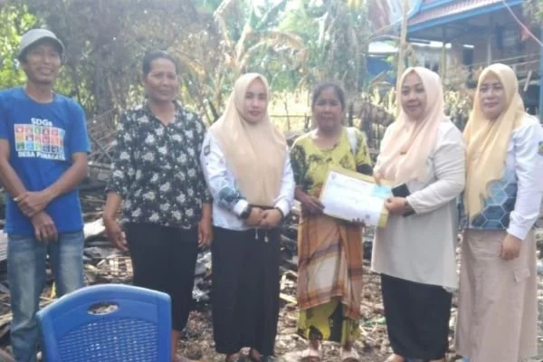 Staff Dinas Dukcapil Jeneponto saat menyerahkan dokumen Adminduk dan bantuan kepada korban kebakaran (Dok : Ist).