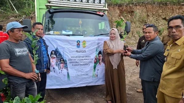 Sekda Jeneponto, Maskur, saat menyerahkan bantuan bibit kopi kepada Kepala Desa Tompobulu. (Ist).