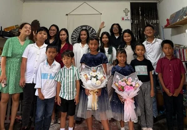 Foto bersama Pendiri Rembang Katapi Music Art Studio, James Tangjong, bersama sang istri (yang juga mengajar kelas Bahasa Inggris) dan 13 murid berprestasi di ruang kerja Rembang Katapi Music Art Studio. (Dok: Ist)