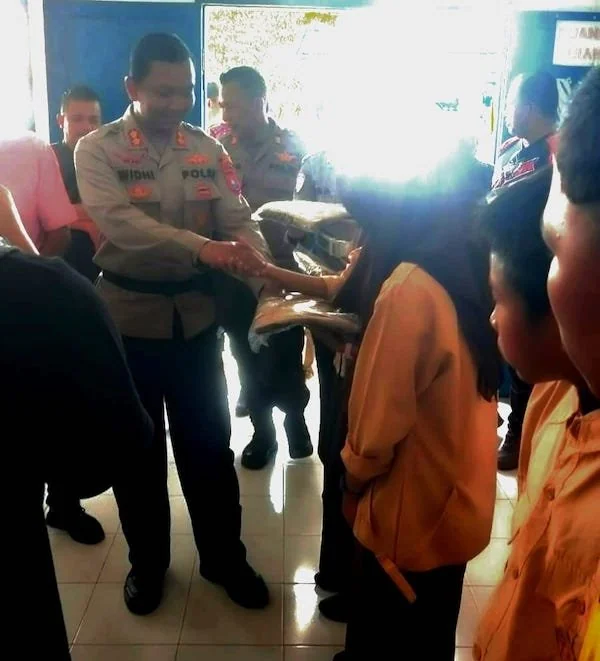 Kapolres Jeneponto AKBP Widi Setiawan saat membagikan seragam dan perlengkapan sekolah gratis bagi pelajar di UPT SMPN Satap 7 Bontoramba, Kecamatan Bontoramba. (Ist).