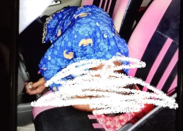seorang pria berpakaian korpri tergeletak dalam mobil.